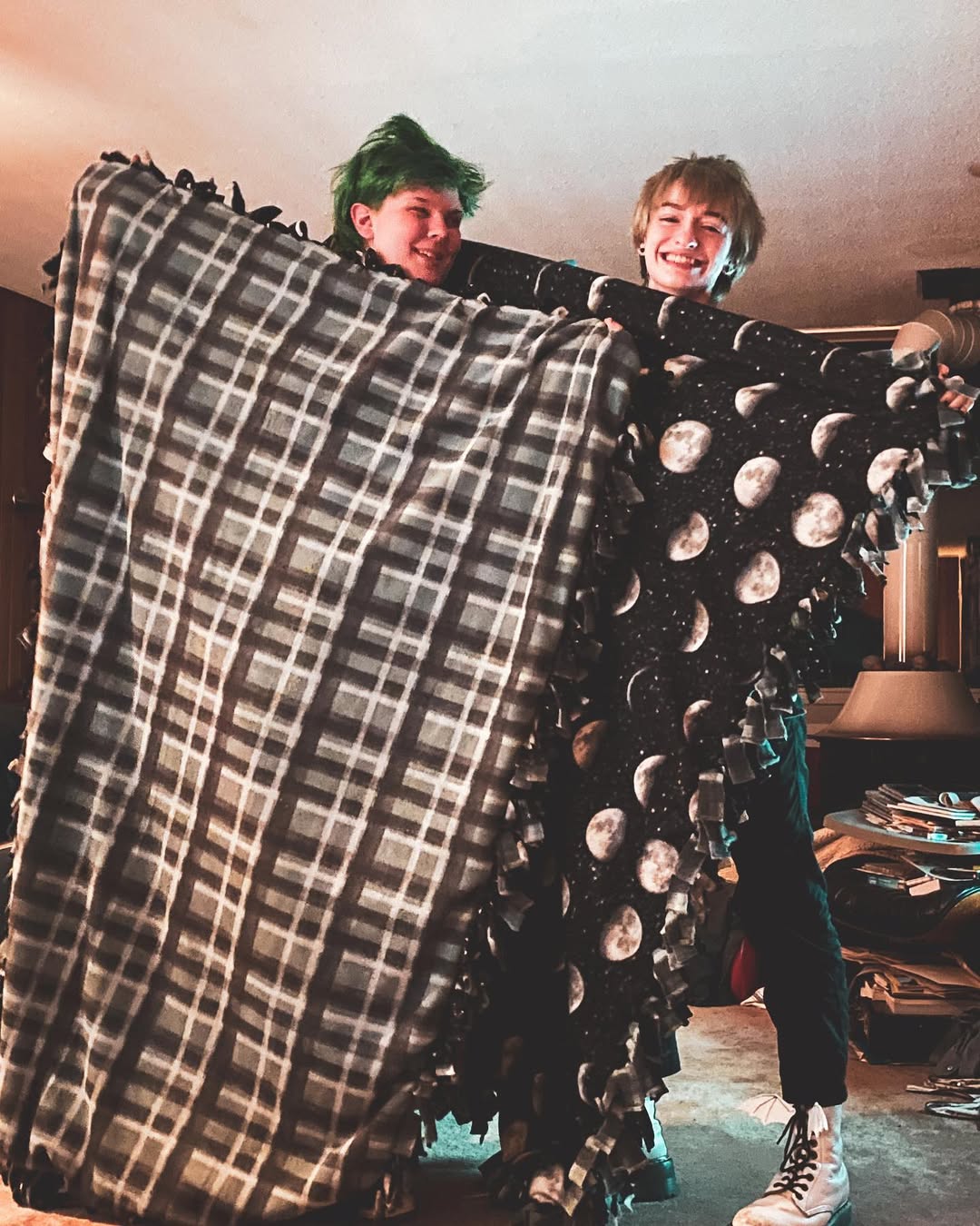 photo of cal and amara holding up completed tie blankets