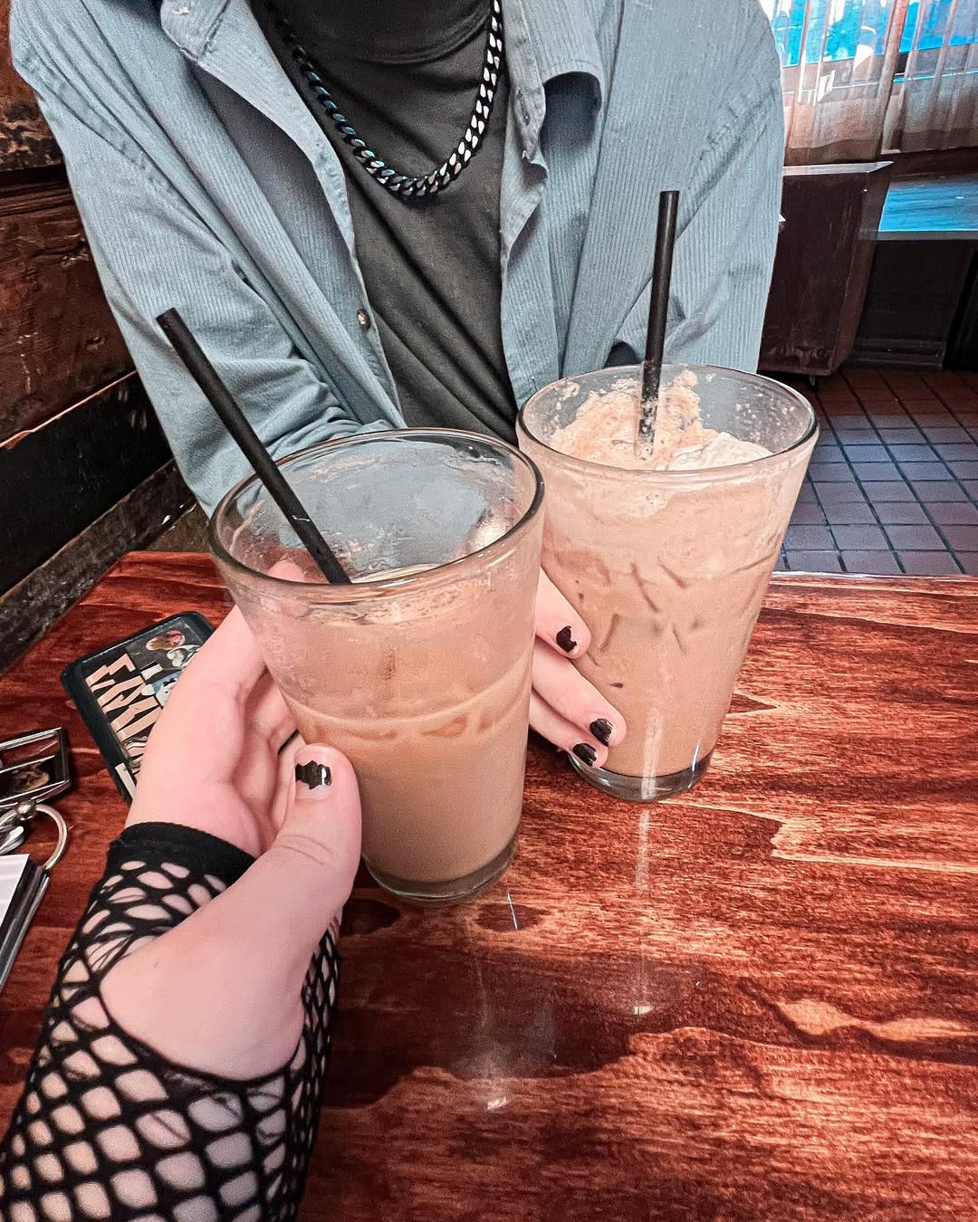 photo of two drinks from a cafe, from the pov of amara