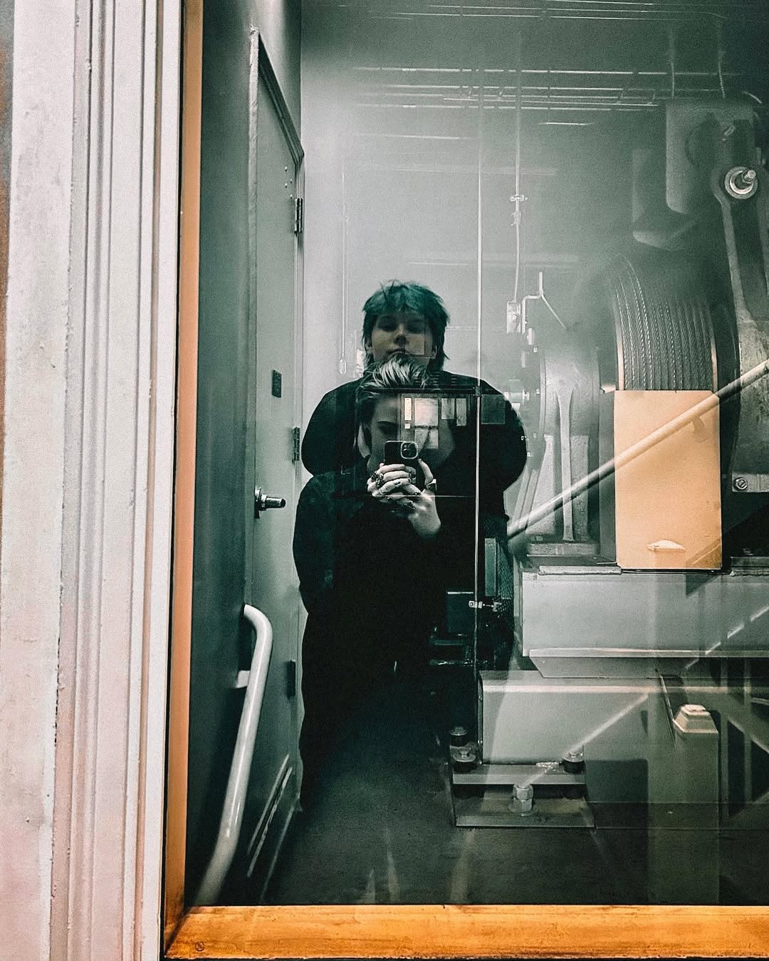 photo of amara and cal in an elevator's reflection