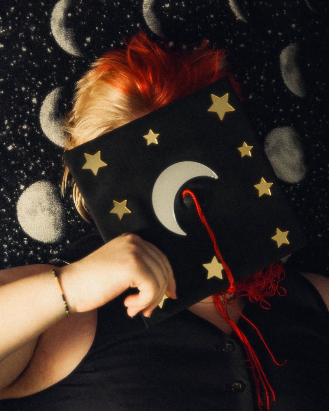 photo of amara with a moon backdrop and grad cap over their face