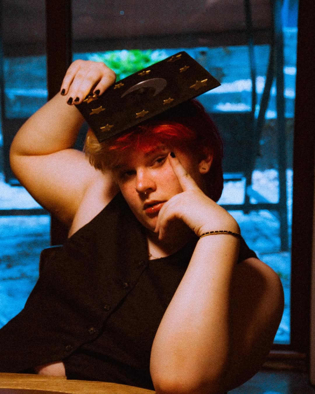 photo of amara with grad cap on, one hand on face and other on grad cap