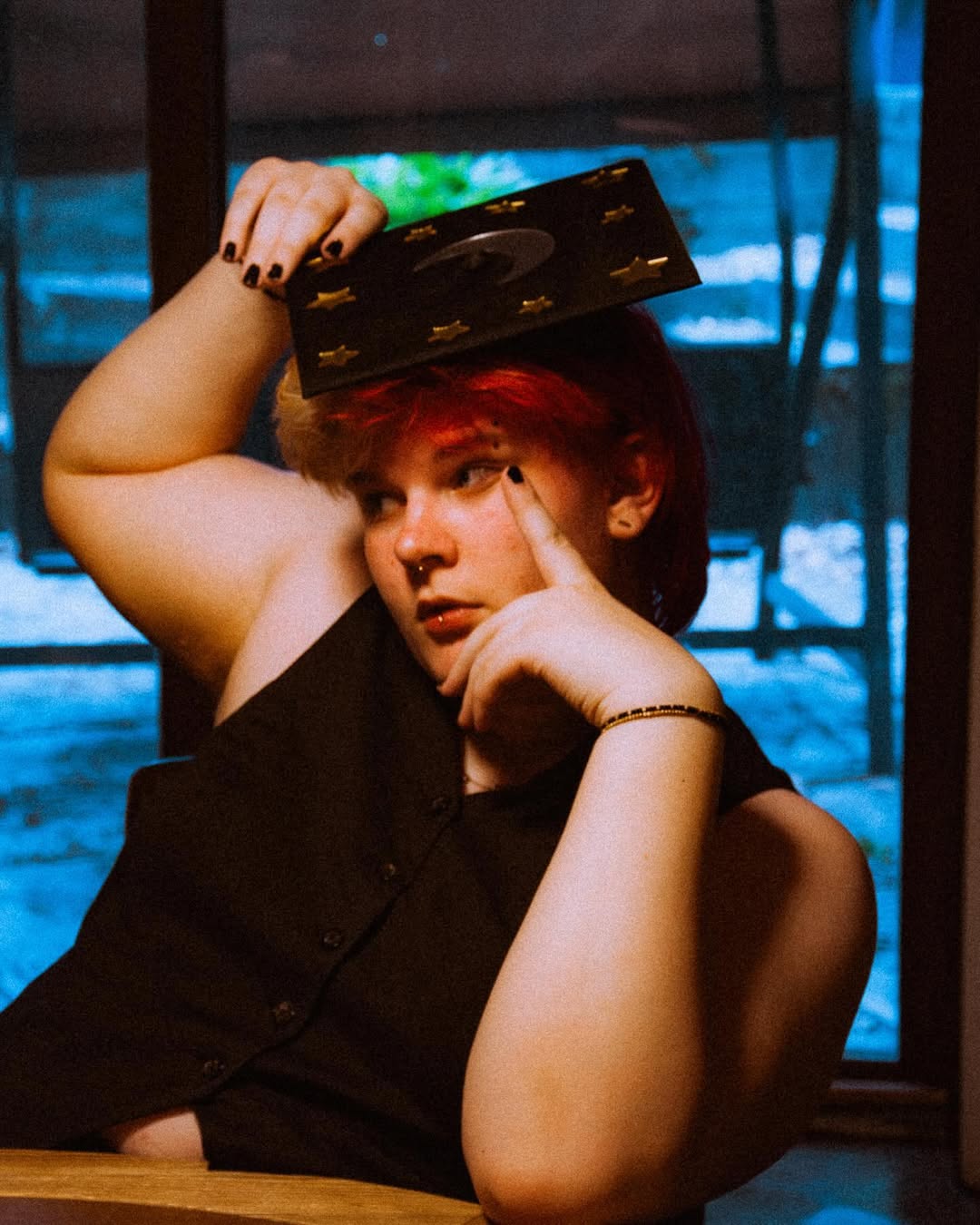 second angle of amara with grad cap on, one hand on face and other on grad cap