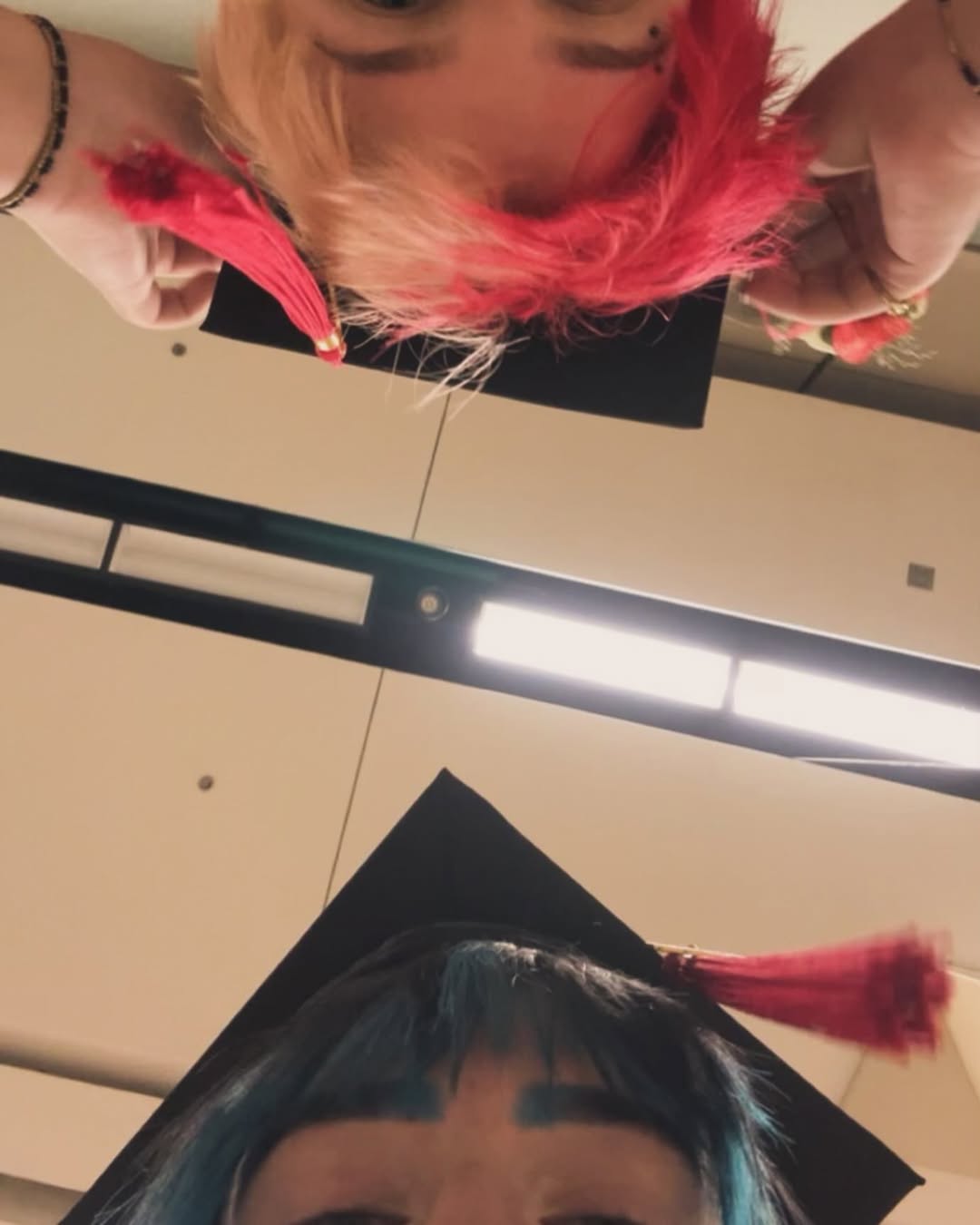 photo barely showing the hair and grad caps of amara and cal